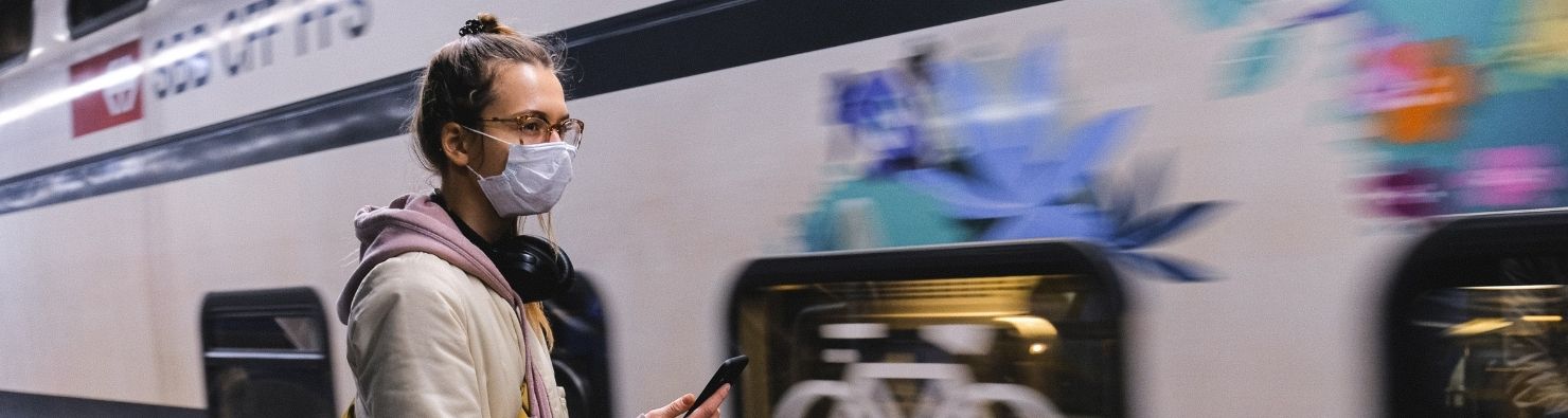 жінка в масці біля поїзда